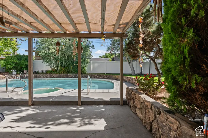 Covered patio area with a built-in swimming pool and spa
