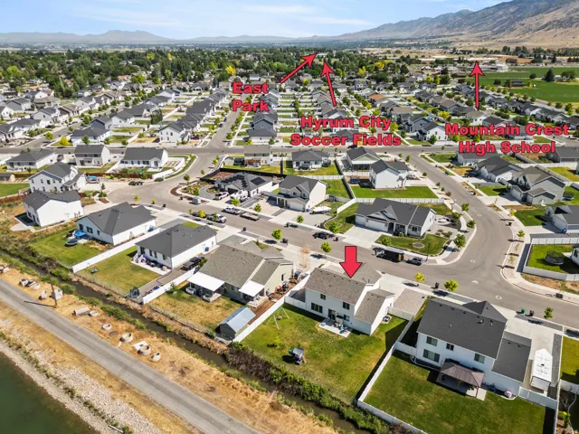 Aerial perspective of a residential neighborhood featuring detached homes with dark roofs and light-colored exteriors