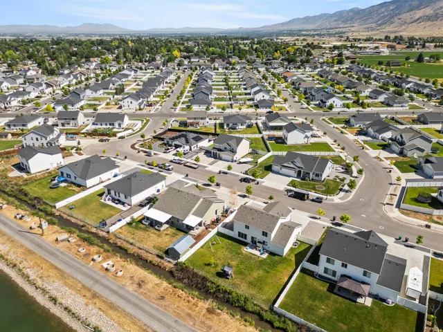 Aerial perspective of a developed residential community featuring single-family homes with dark roofs and light-colored exteriors