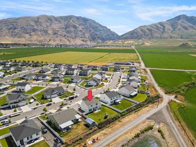 Aerial perspective highlighting a residential development bordered by open fields and distant mountains