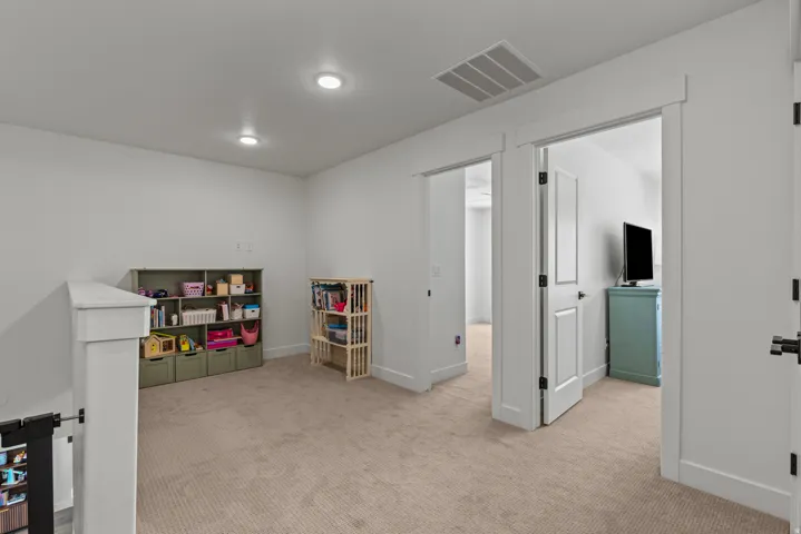 Carpeted landing area featuring recessed lighting, white walls, and bright white trim