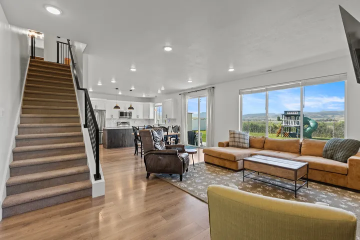 Open-concept living space featuring wood-finish flooring, recessed lighting, and a neutral color palette