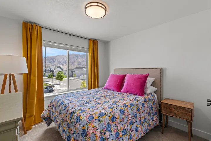 Bedroom with large window, neutral wall paint, and ceiling-mounted light fixture