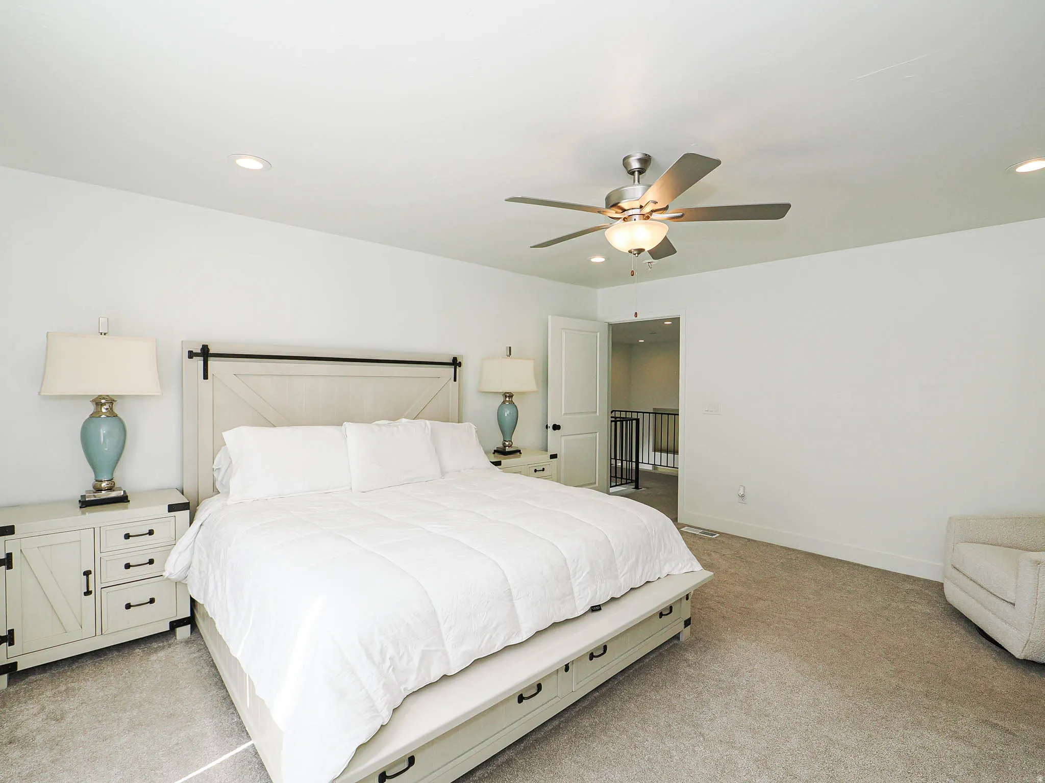 Spacious room featuring neutral carpeting, recessed lighting, and a ceiling fan with light fixture