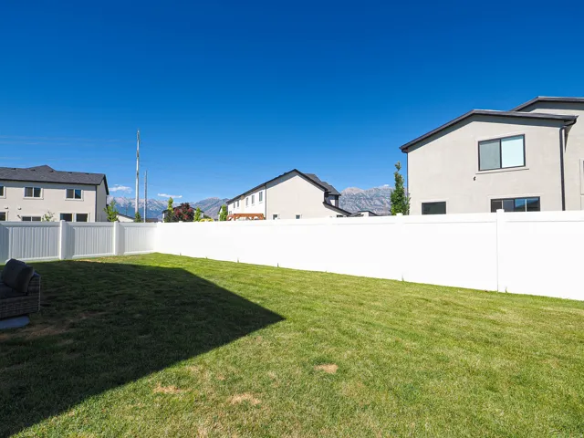 Expansive lawn area enclosed by a white privacy fence