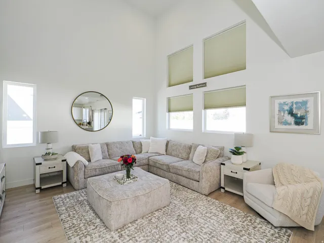 Vaulted ceiling living area featuring wood-finish flooring
