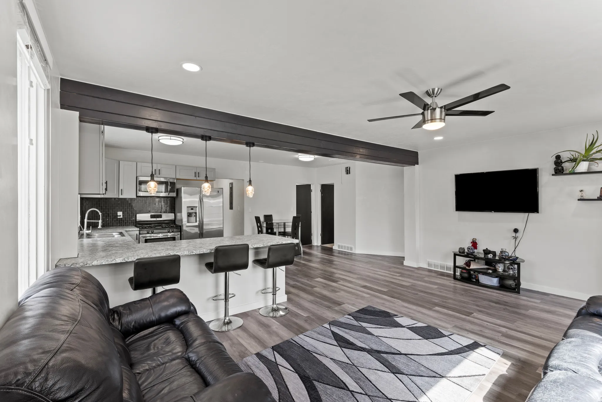 Open-concept living area with wood-finish flooring extending into the kitchen