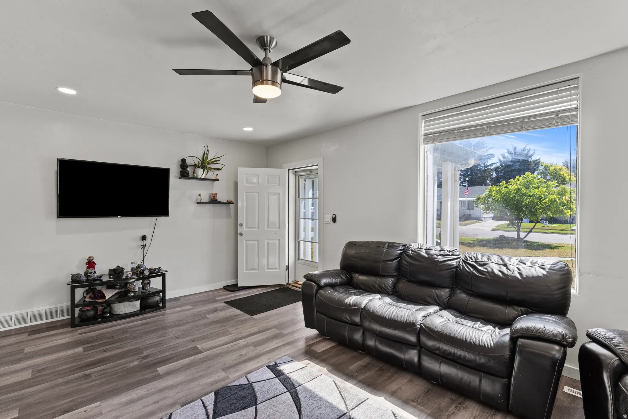 Bright living space featuring wood-finish flooring, recessed lighting, and a contemporary ceiling fan