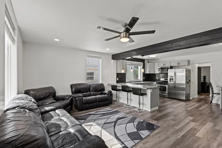 Open-concept living space featuring wood-finish flooring, recessed lighting, and a contemporary ceiling fan