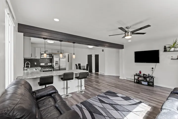 Open-concept living area with wood-finish flooring extending into the kitchen