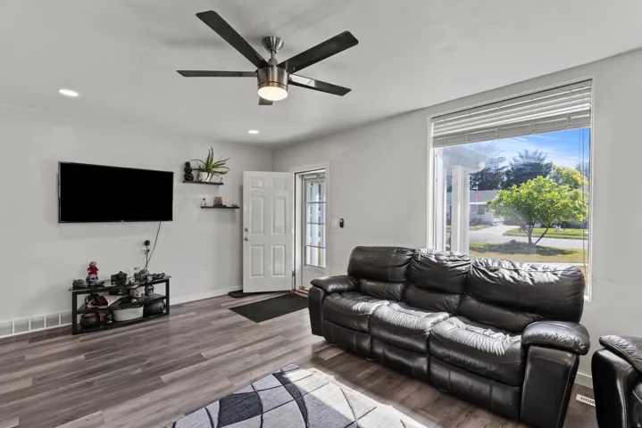 Bright living space featuring wood-finish flooring, recessed lighting, and a contemporary ceiling fan