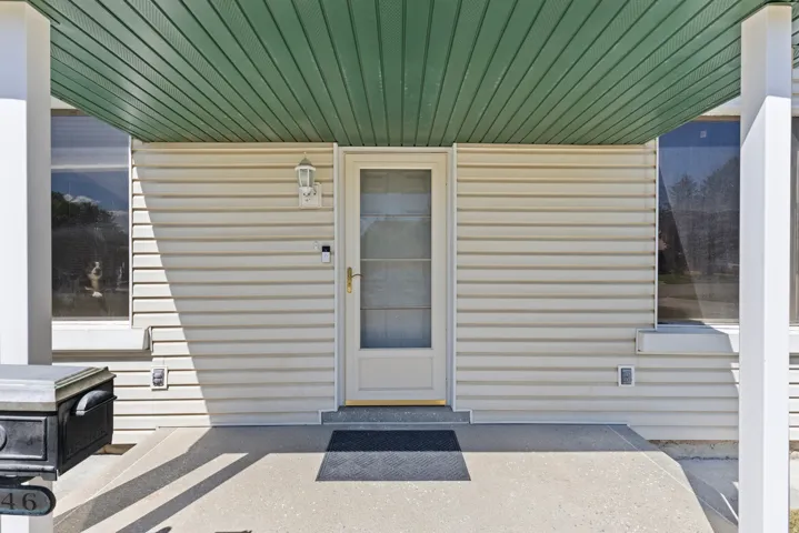Entryway featuring beige horizontal siding and a green soffit