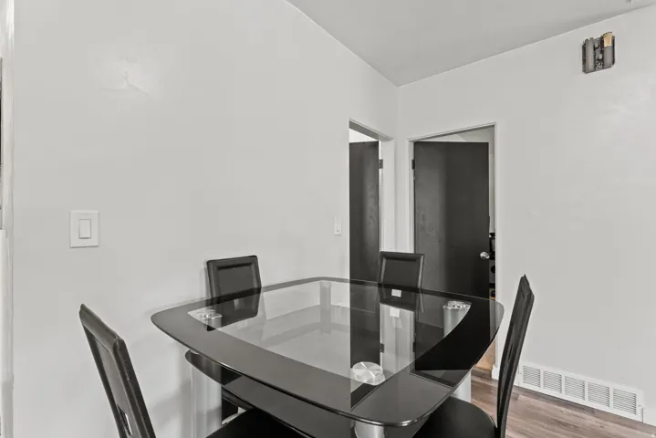 Dining area featuring light-toned walls and wood-finish flooring