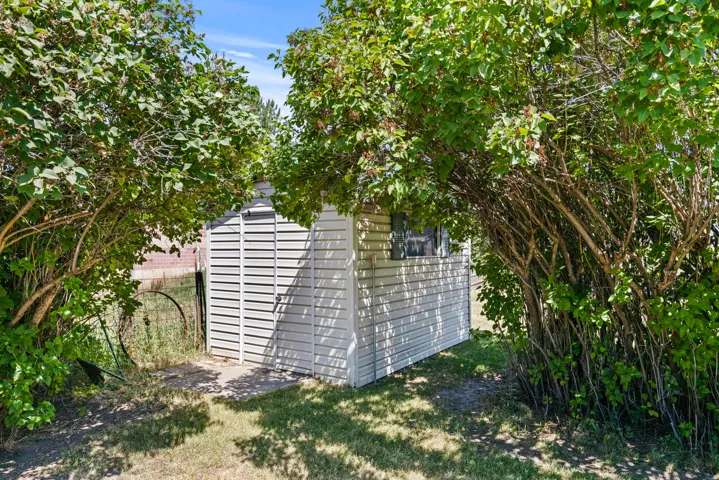 Detached storage shed with siding exterior, single window, and concrete pad