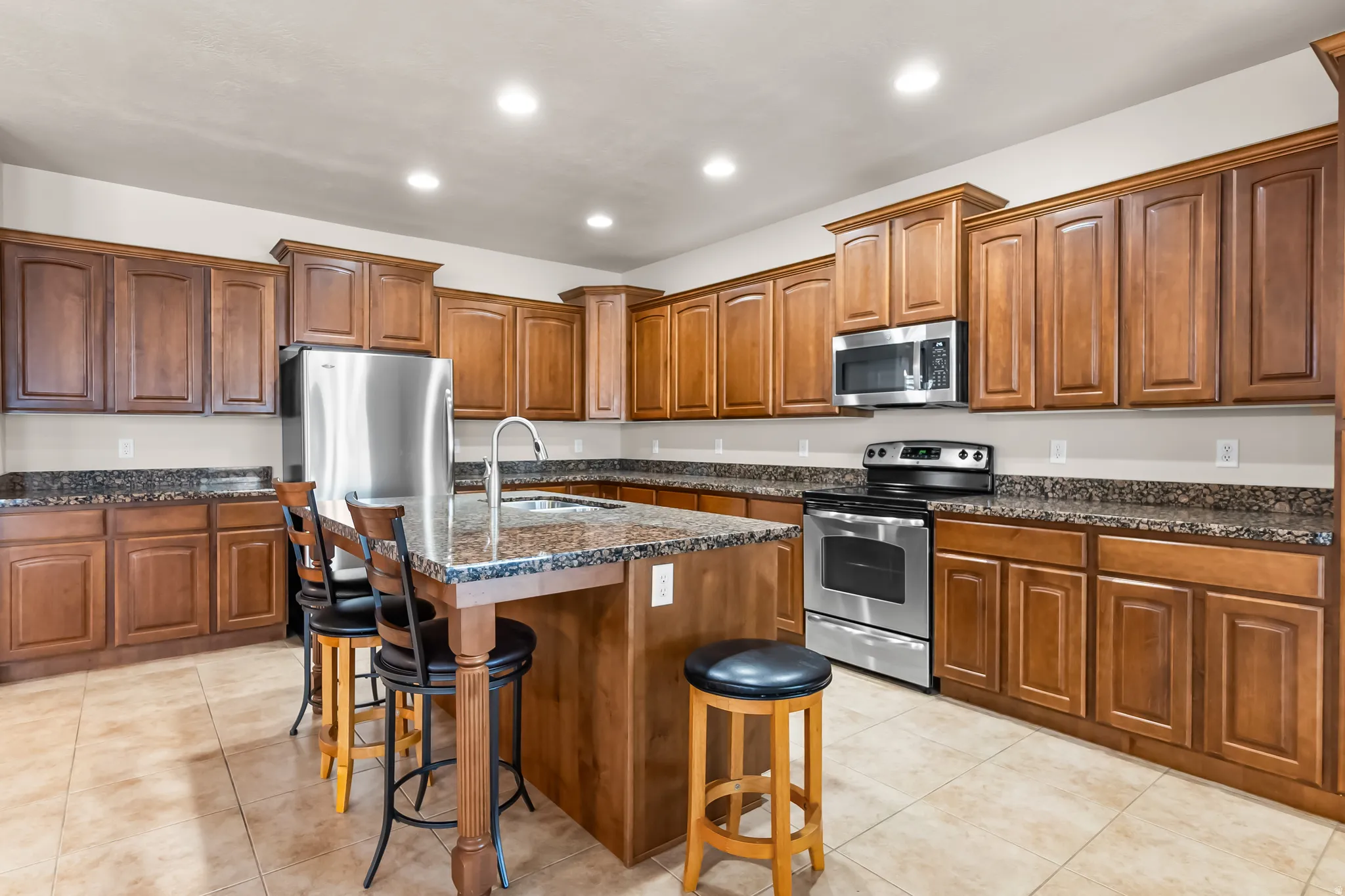 Kitchen featuring a central island with an undermount sink and countertop seating