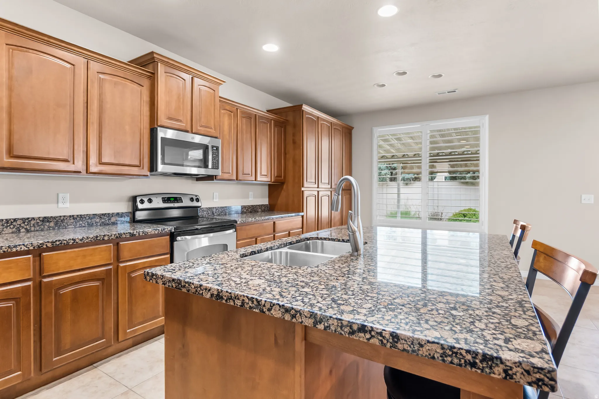Spacious kitchen featuring an expansive island with a double basin sink and a gooseneck faucet