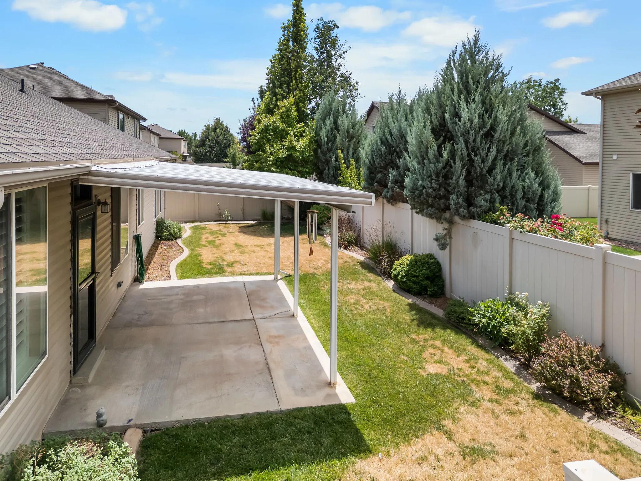 Concrete patio featuring an attached patio cover, vinyl siding, and a privacy fence
