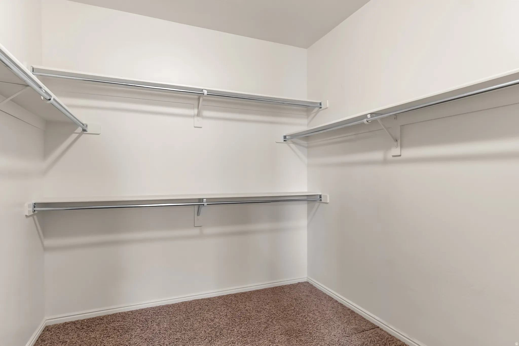 Walk-in closet featuring extensive wire shelving and hanging rods