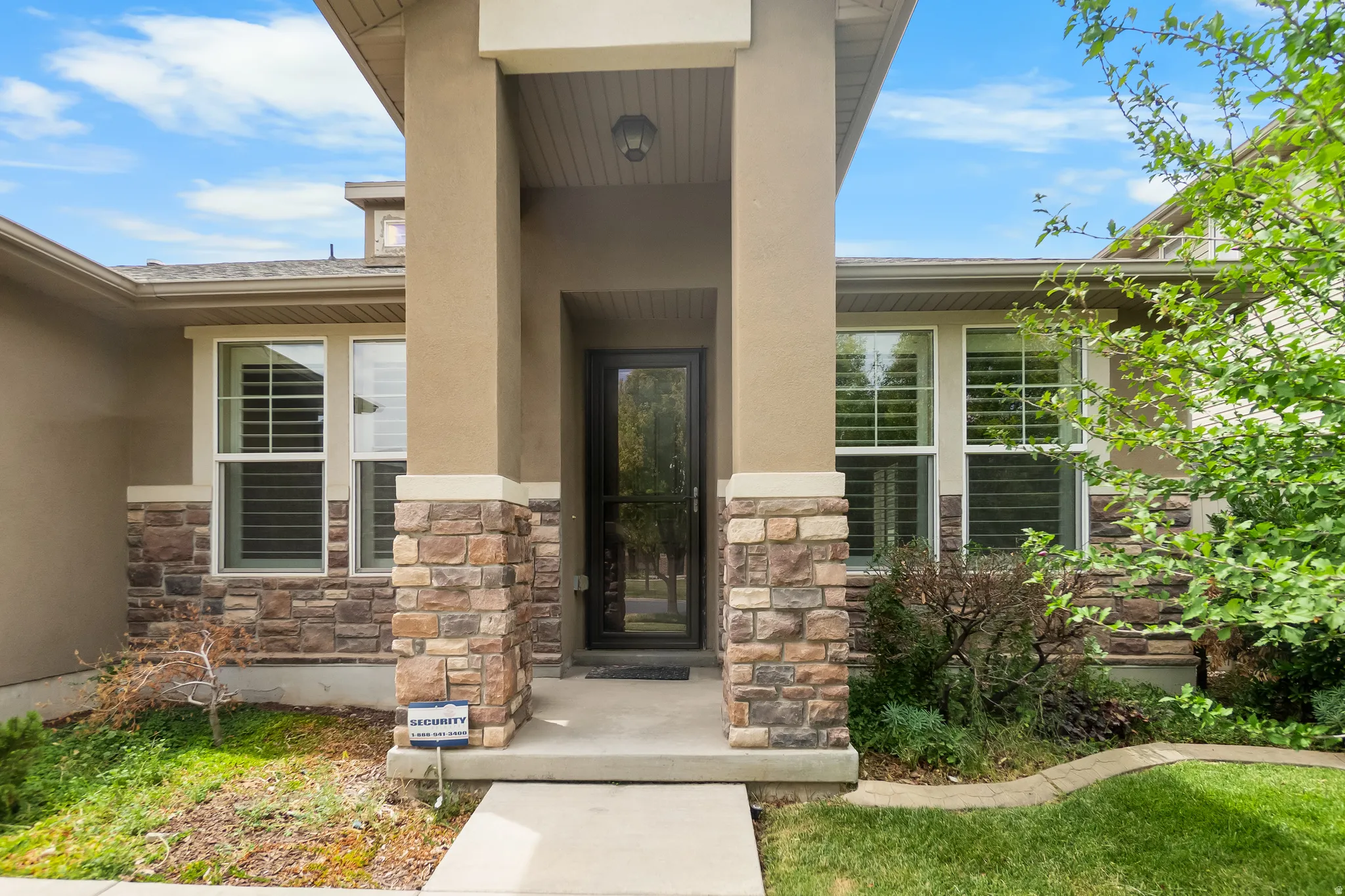 Stone veneer and stucco exterior with an inviting covered entryway