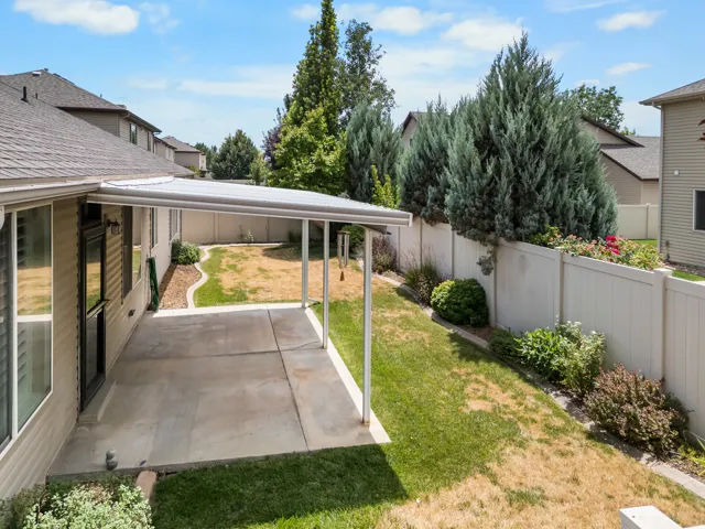 Concrete patio featuring an attached patio cover, vinyl siding, and a privacy fence