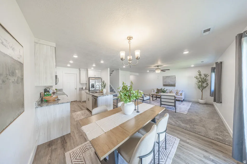 Open-concept living area with a dining space, kitchen, and living room.  Lots of lighting.  Lots of NATURAL LIGHT.