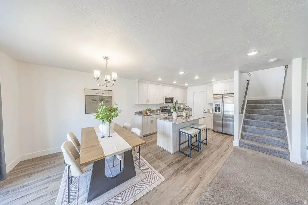 Open-concept living space featuring a dining area, kitchen, and staircase.