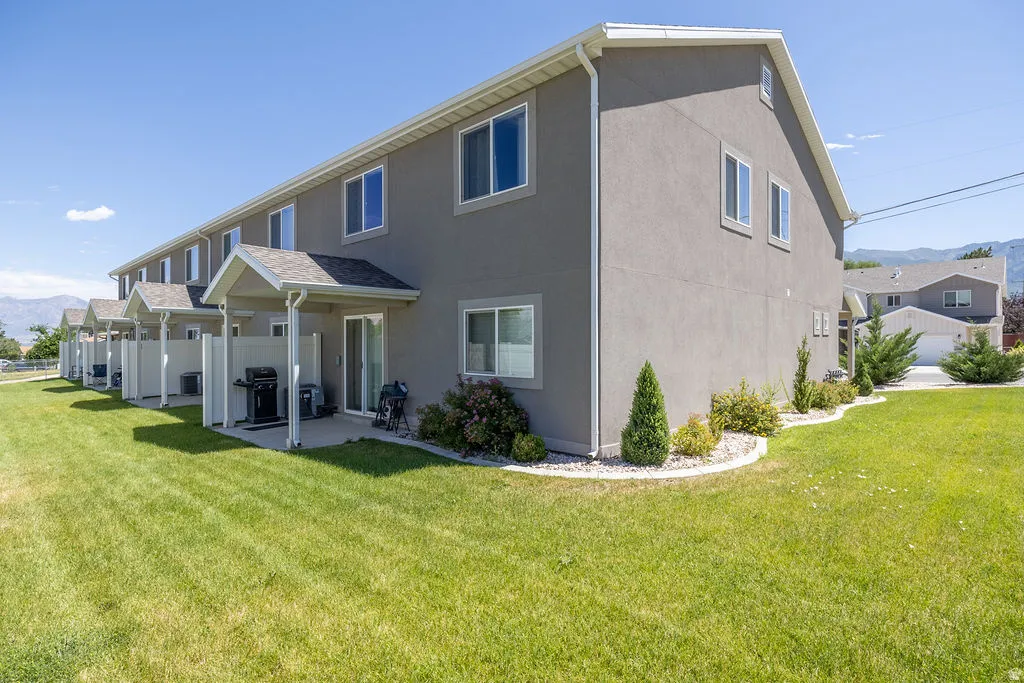 Townhome exterior with stucco siding and white trim.  Green space around this END UNIT.