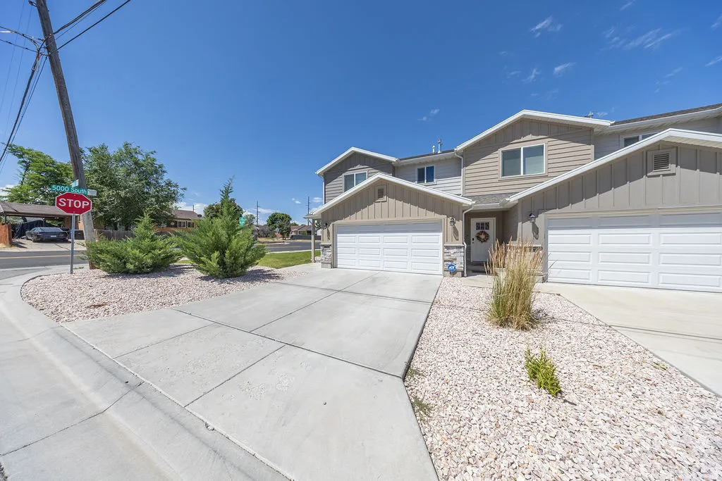 Contemporary multi-level exterior.  Attached garage.  Concrete driveway.  Low-maintenance landscaping featuring decorative rock and established shrubs.