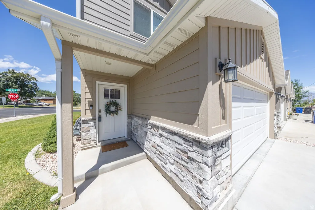 Exterior features include horizontal siding, vertical board, and stone veneer detailing.