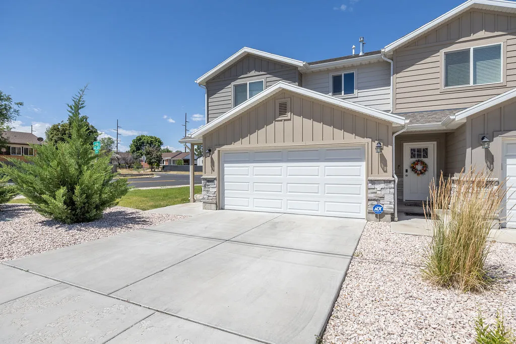 Two-story residence featuring a two-car garage with white panel doors and an inviting front entry
