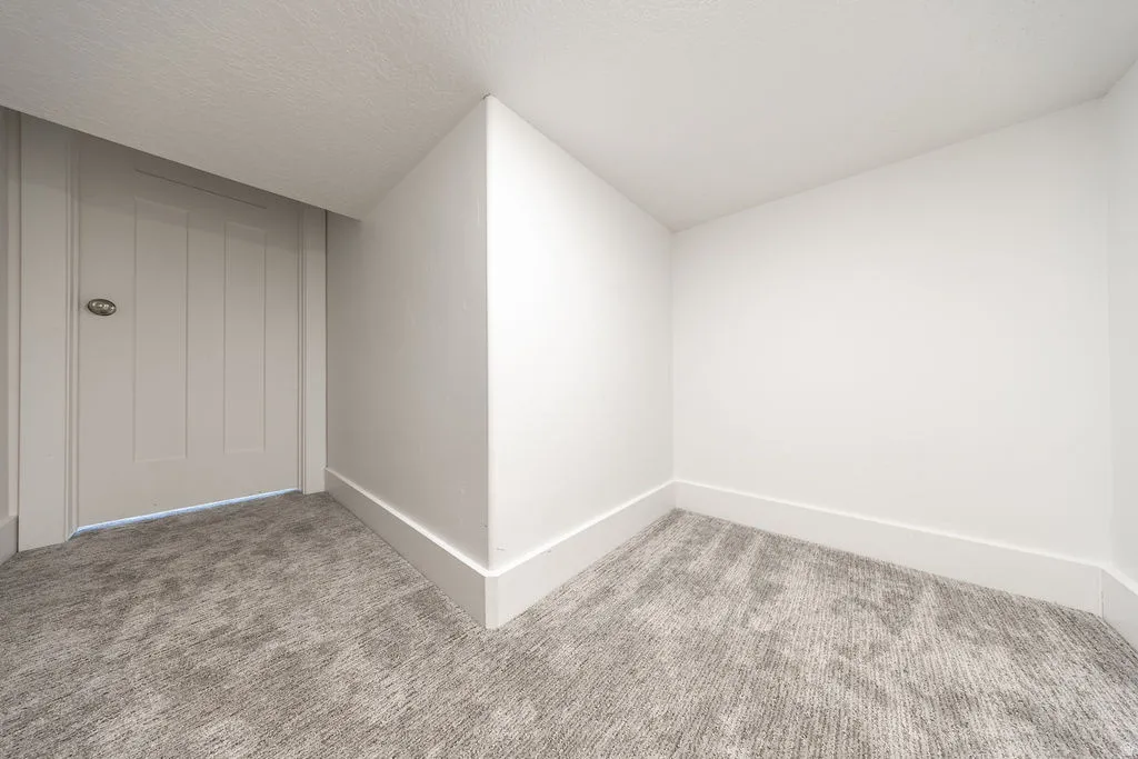 Neutral-toned wall-to-wall carpeting and crisp white walls