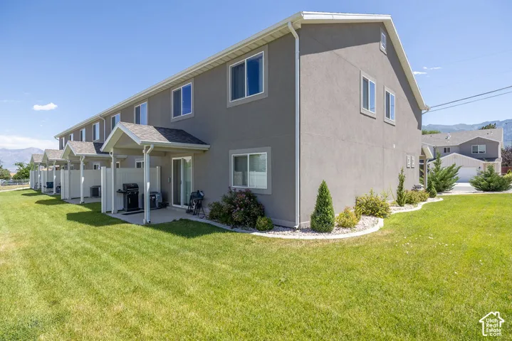 Townhome exterior with stucco siding and white trim.  Green space around this END UNIT.