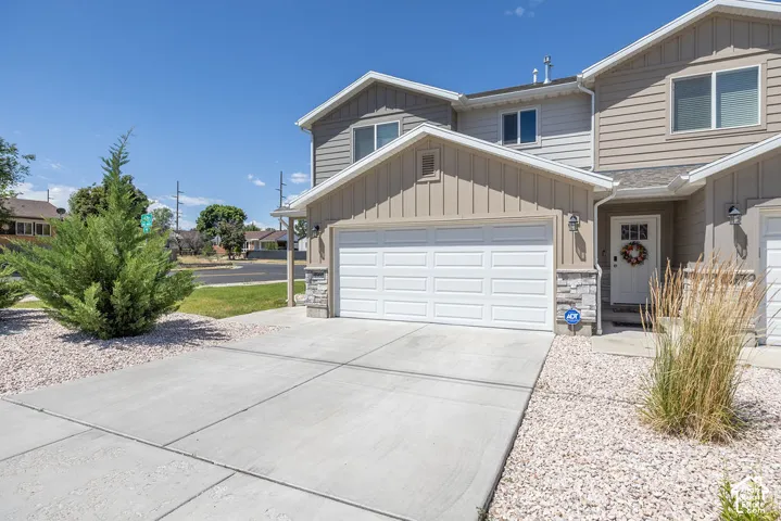 Two-story residence featuring a two-car garage with white panel doors and an inviting front entry