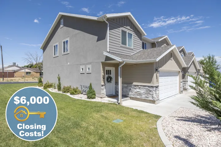 Multi-unit property with stucco and horizontal siding, stacked stone accents, attached garage, and landscaping with mature shrubs