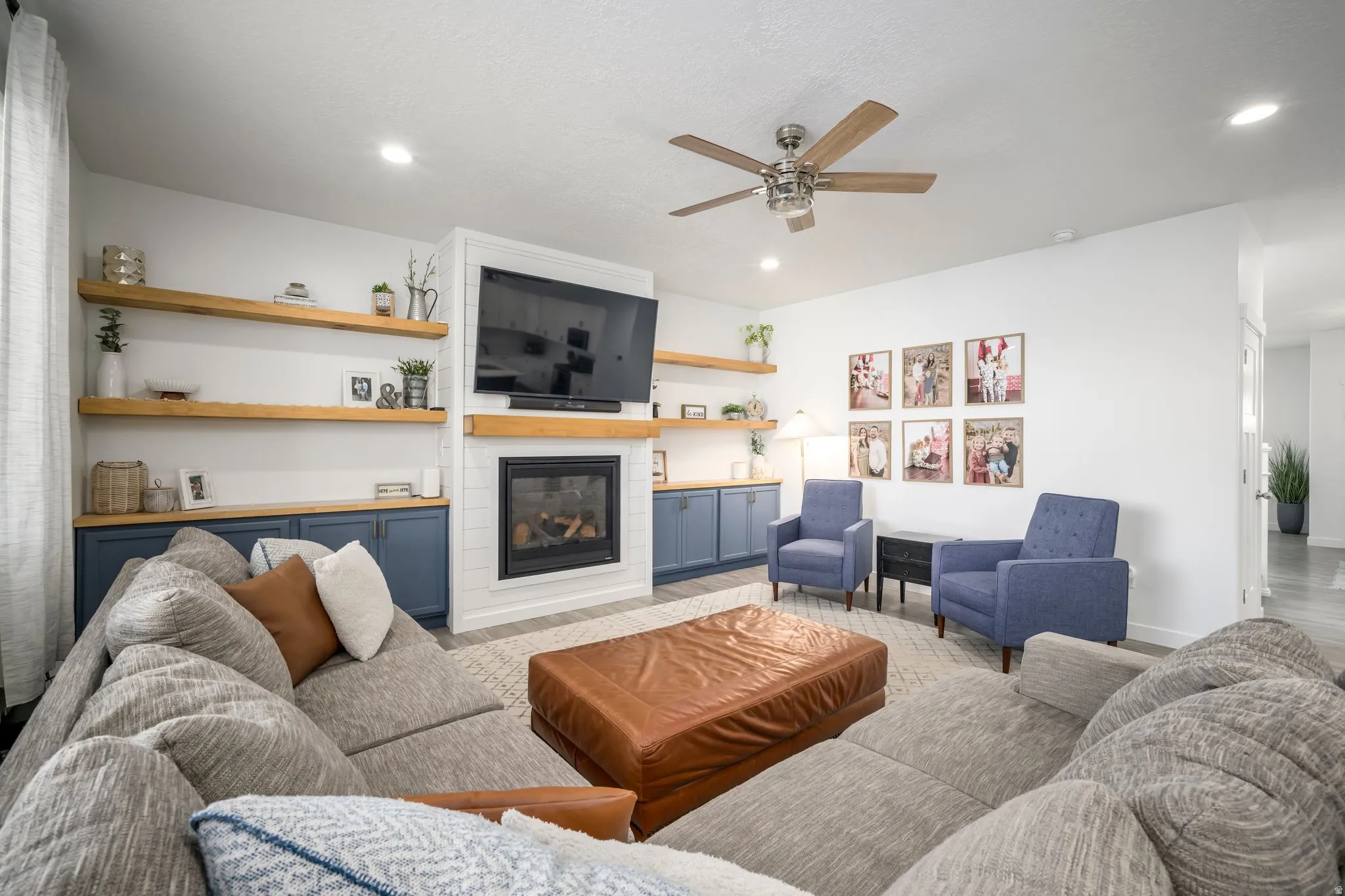 Living area featuring a fireplace with white tile surround and wood mantel, flanked by built-in cabinetry with wood countertops and open shelving