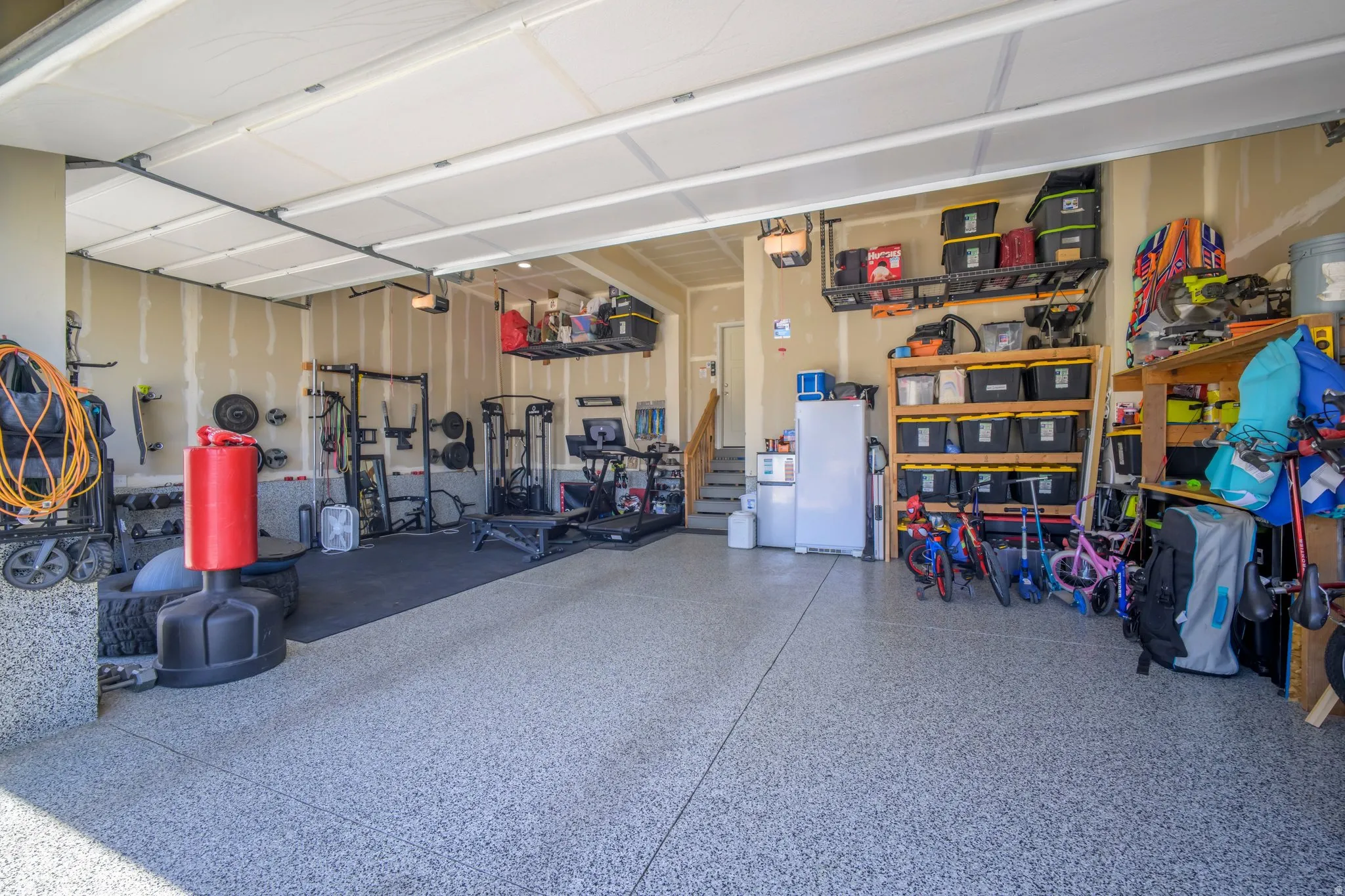 Spacious garage featuring a durable epoxy floor coating and overhead garage door