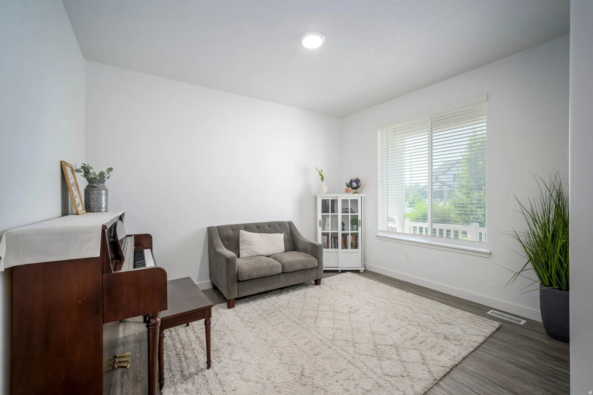 Spacious interior featuring wood-finish flooring, recessed lighting, and a large window with white blinds