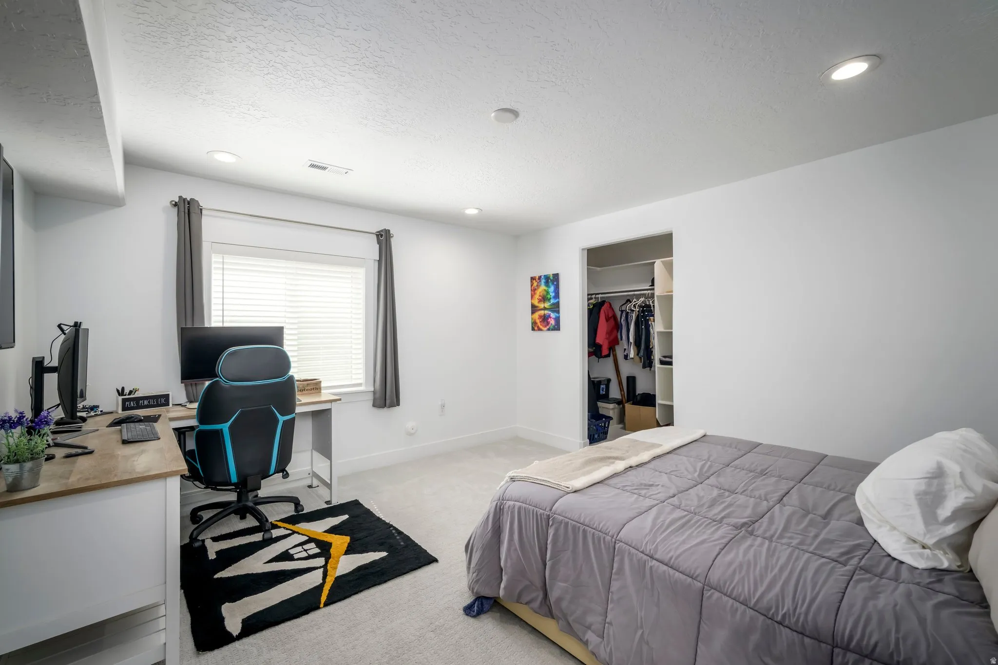 Neutral-toned room featuring a window with blinds, recessed lighting, and light-colored carpeting