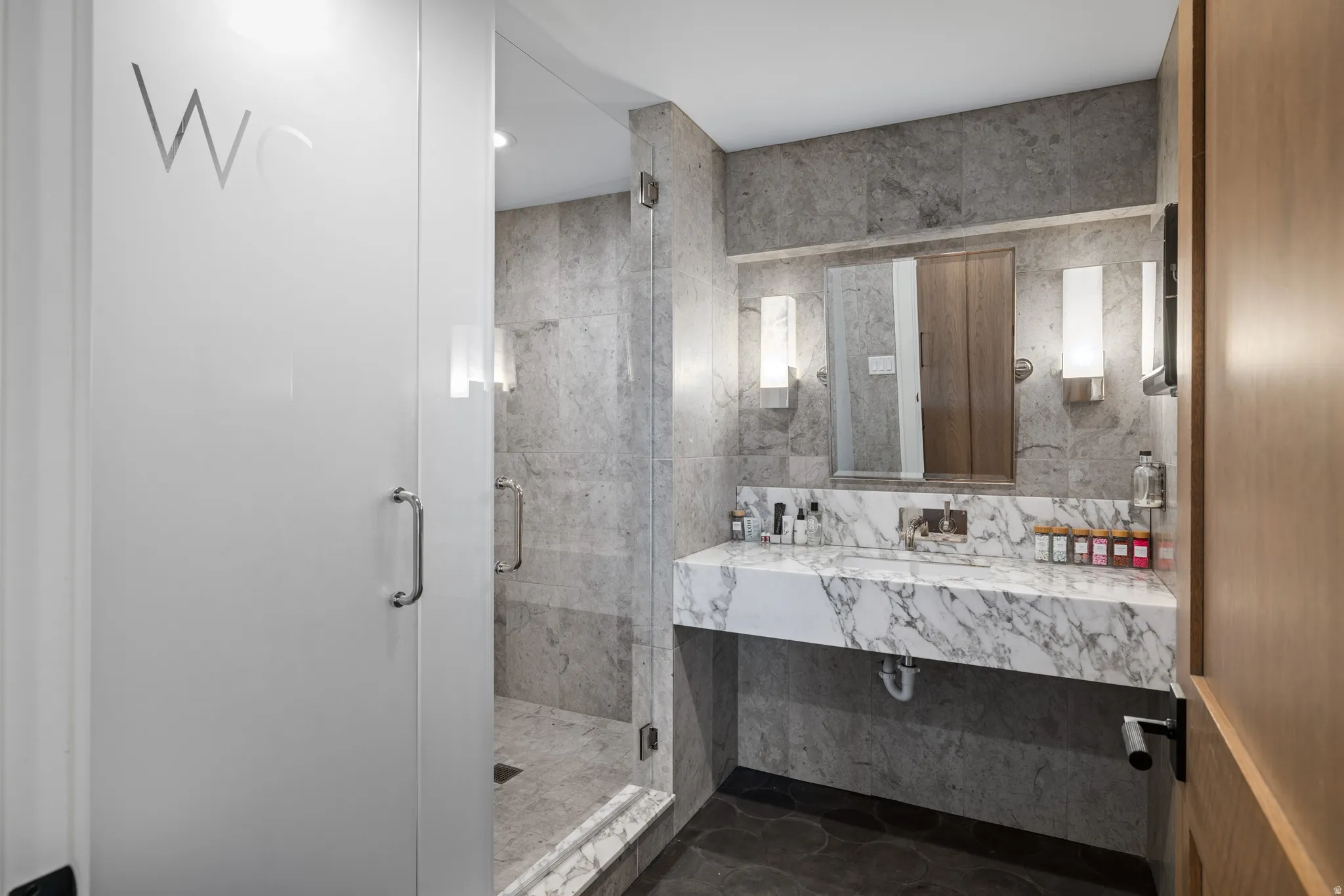 Modern bathroom featuring a floating marble-finish vanity with an integrated basin and wall-mounted faucet
