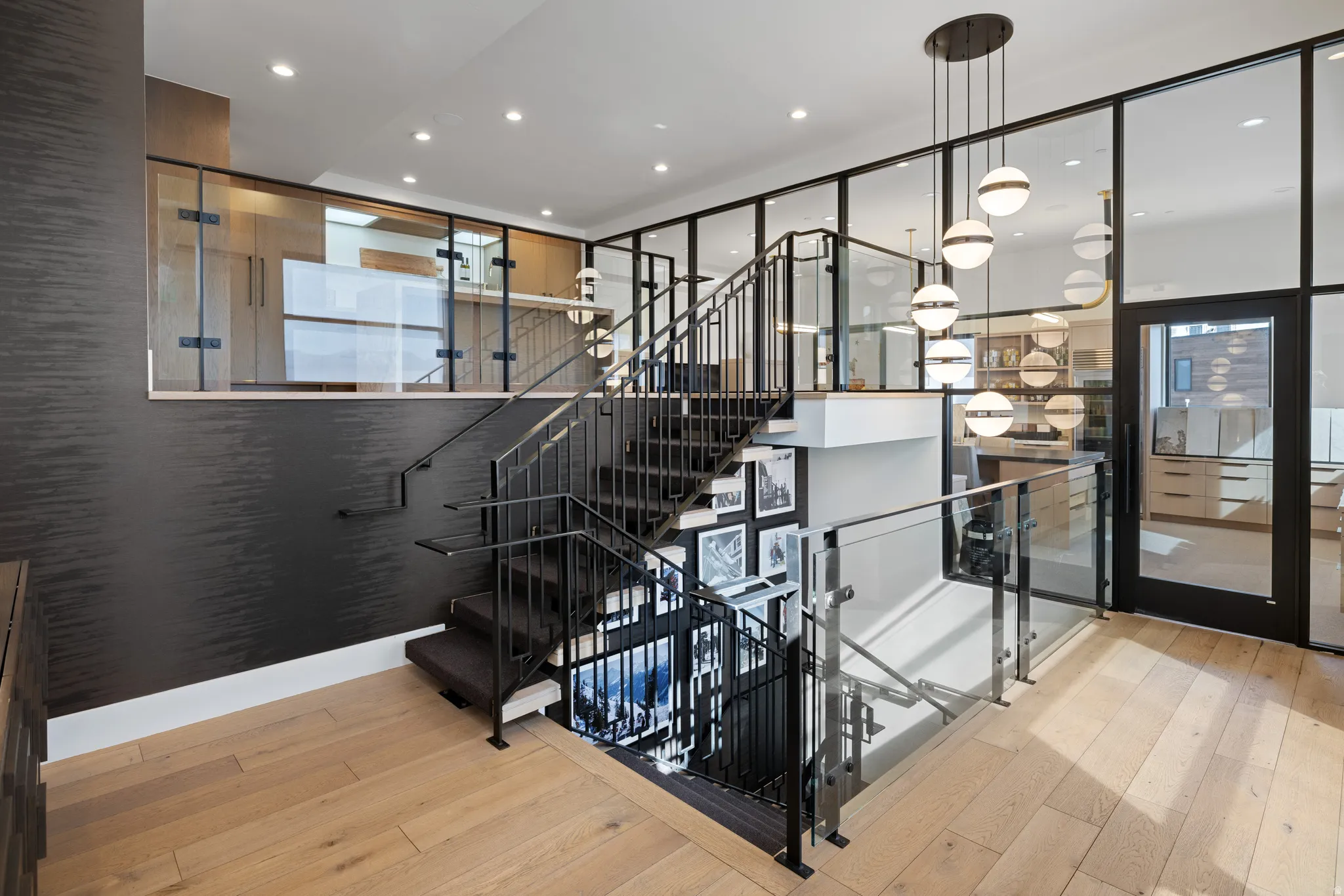Modern multi-level staircase featuring black metal railings and glass balustrades