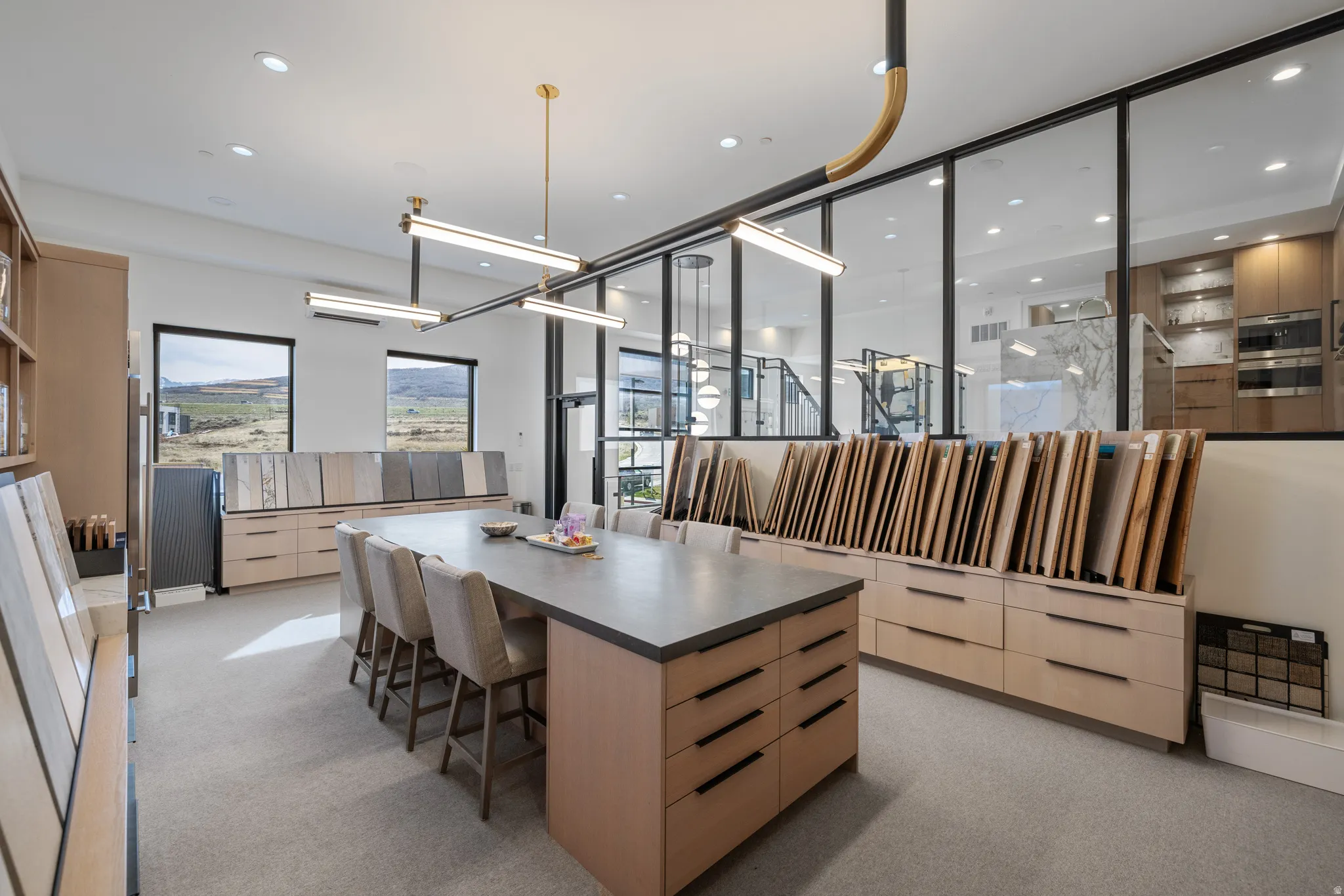 Spacious interior with an oversized central island featuring a dark countertop and light wood-finish cabinetry