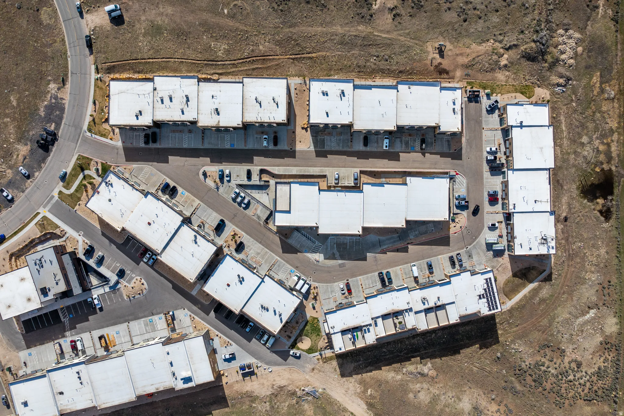 Community of multi-story buildings with flat roofs and individual parking spaces