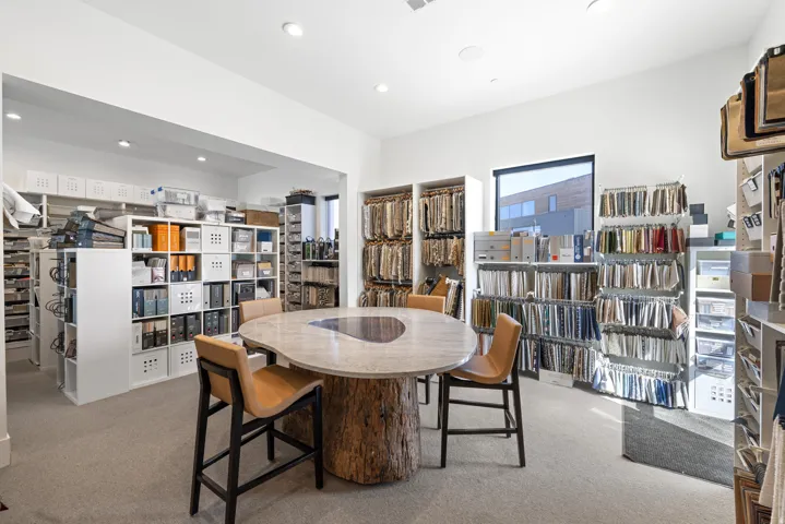 Spacious room featuring neutral carpeting and a central wood-base table with a stone top