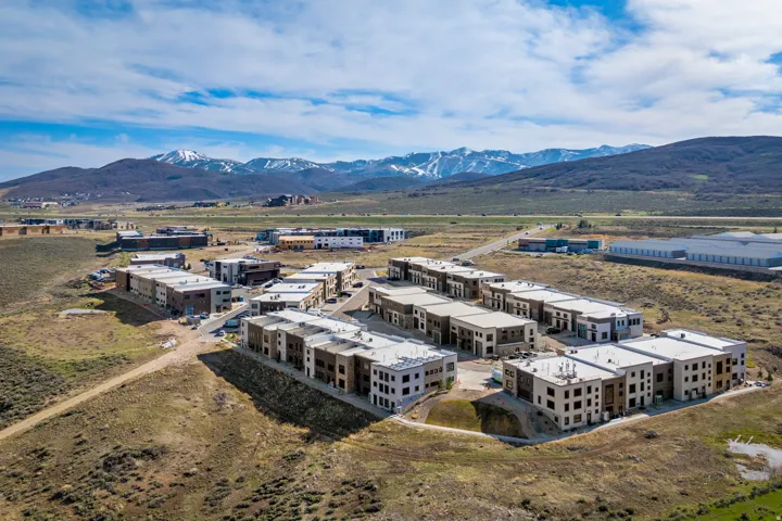 Modern multi-level residential structures featuring varied architectural facades, flat roofs, and integrated window designs
