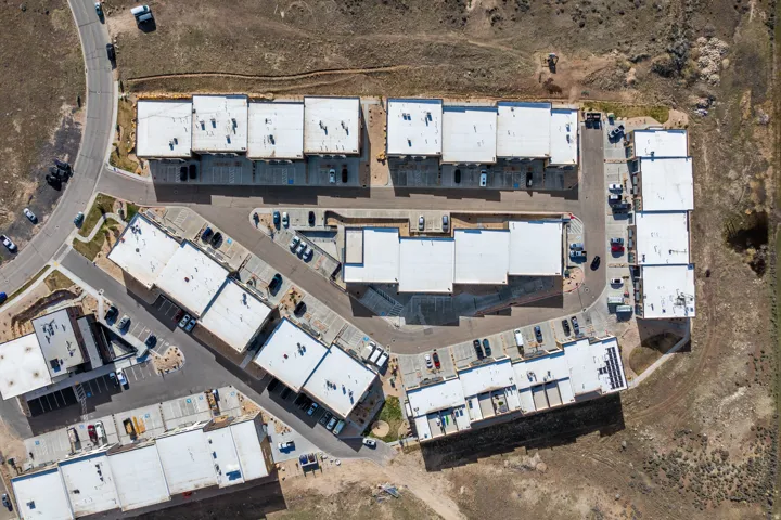 Community of multi-story buildings with flat roofs and individual parking spaces