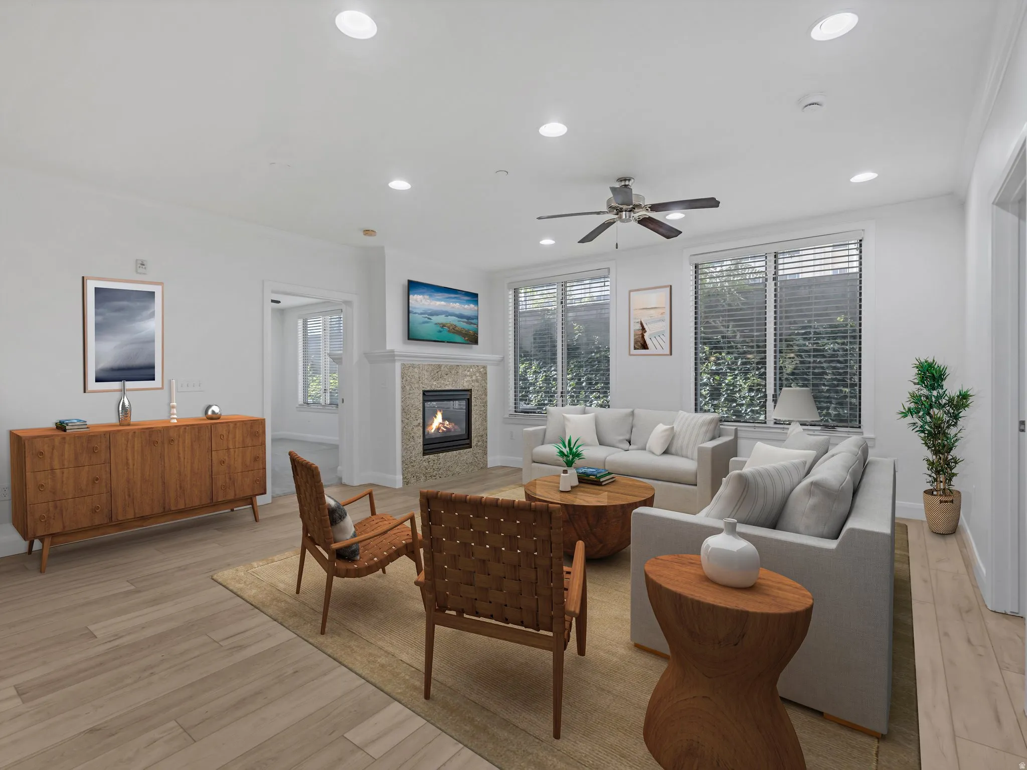 Spacious living area featuring light wood-finish flooring, recessed lighting, and a ceiling fan