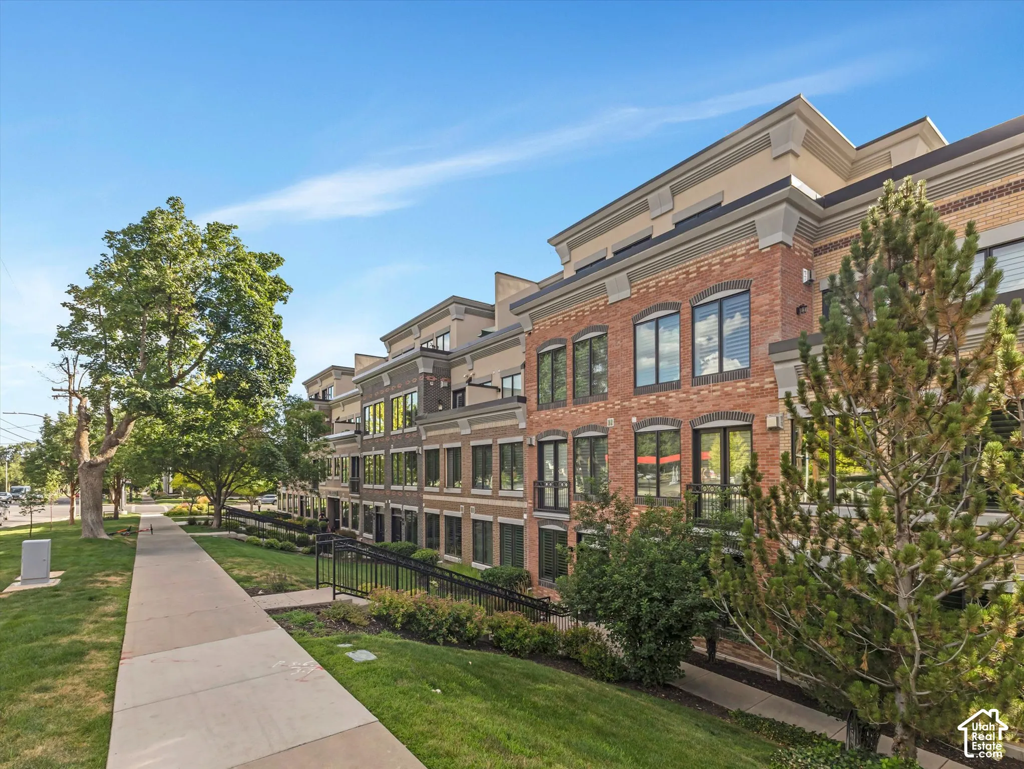 Brick and stucco facade townhouse featuring a multi-story design with prominent windows
