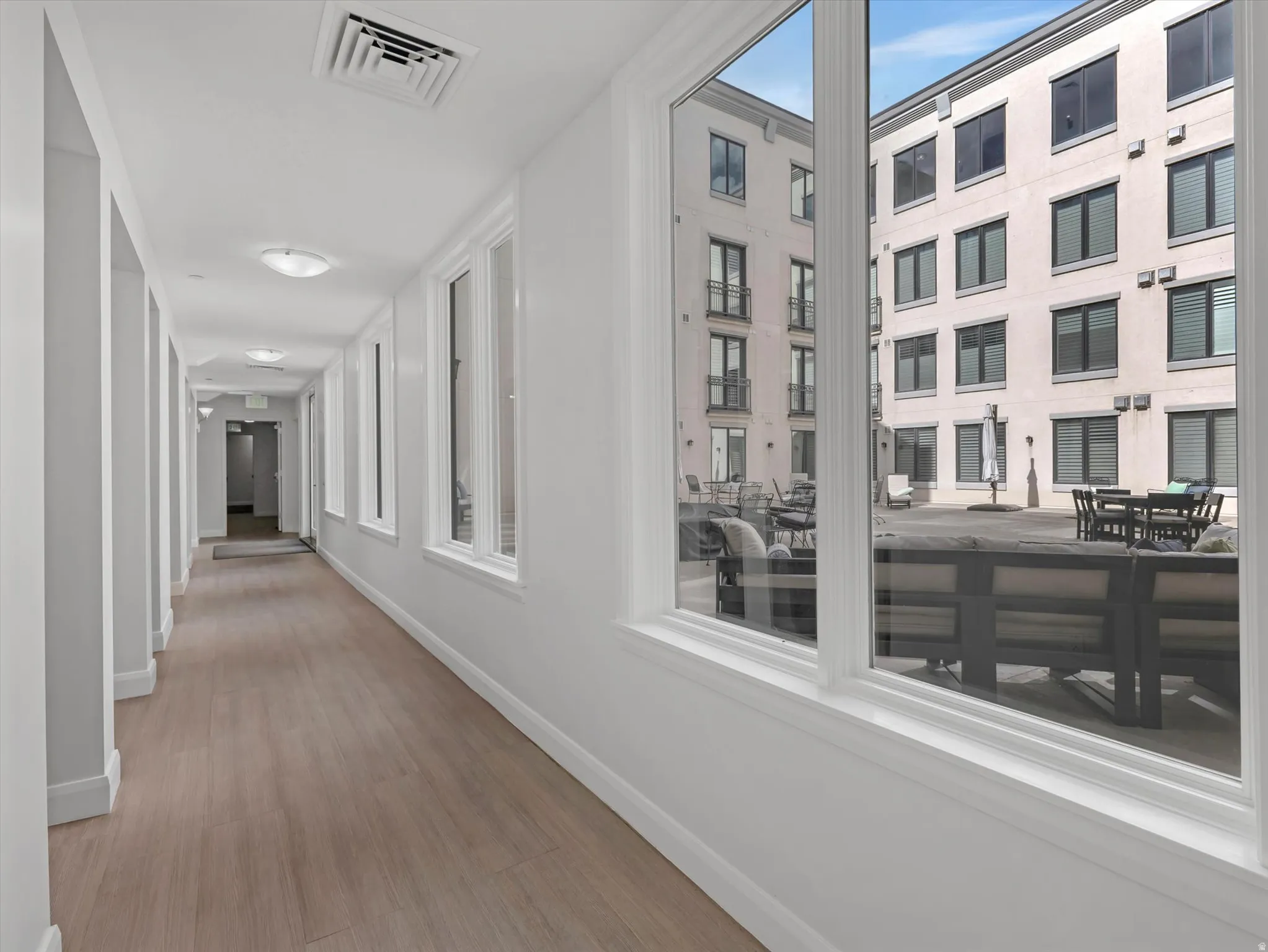 Hallway featuring wood-finish flooring, recessed lighting, and white trim