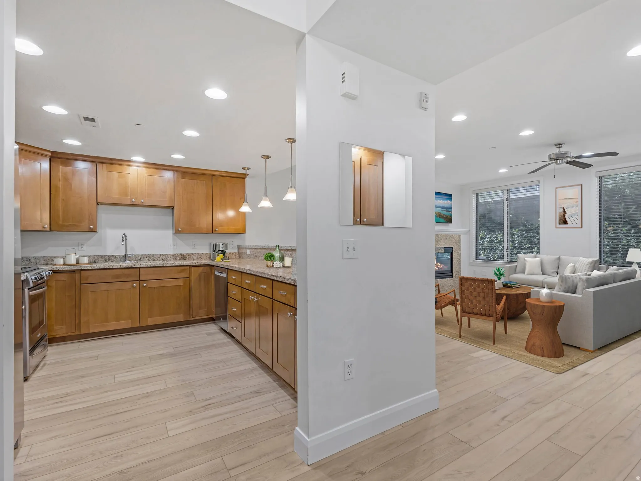 Kitchen featuring wood-finish cabinetry, granite-style countertops, stainless steel appliances, and recessed lighting