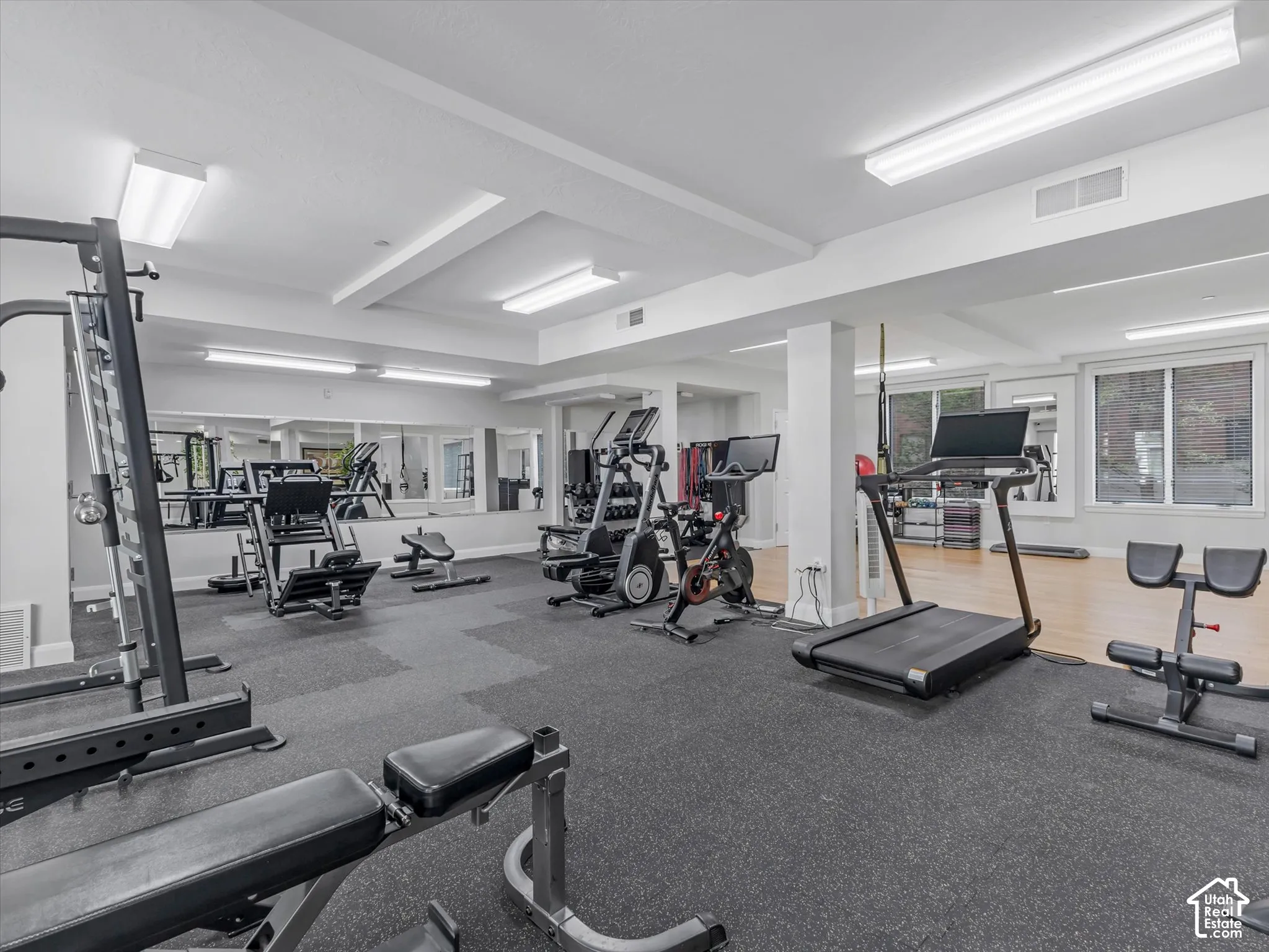 Fitness room featuring a rubberized flooring system and mirrored walls